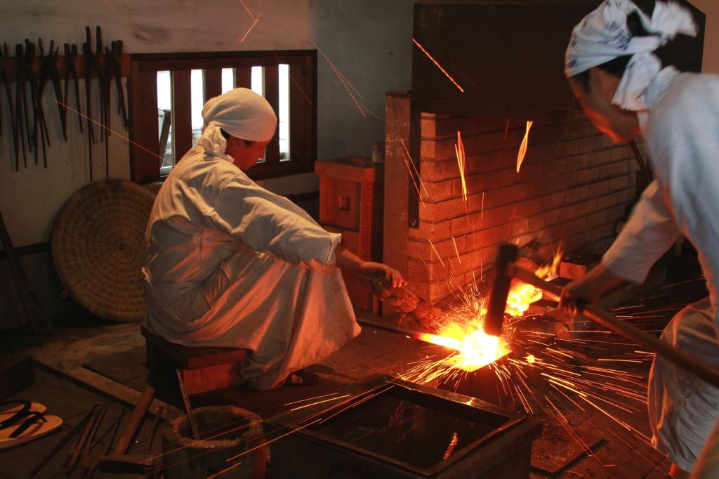 弟子が師と向かい合って互いに槌を打つ